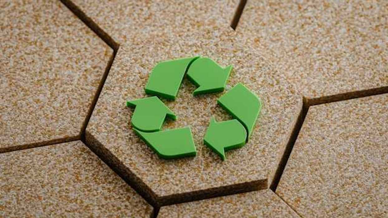 A green recycling symbol on hexagon of cork board elevated amongst other corkboards