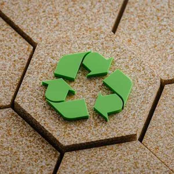A green recycling symbol on hexagon of cork board elevated amongst other corkboards