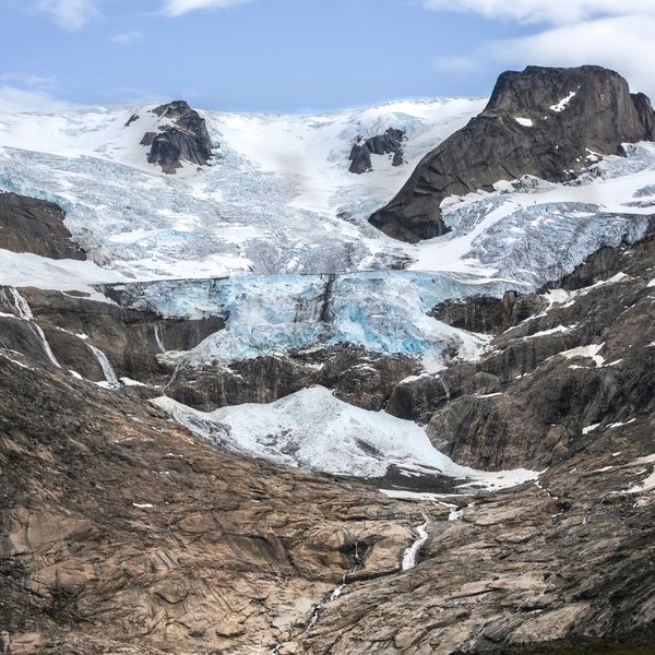A Greenland glacier receding from a brown and gray valley