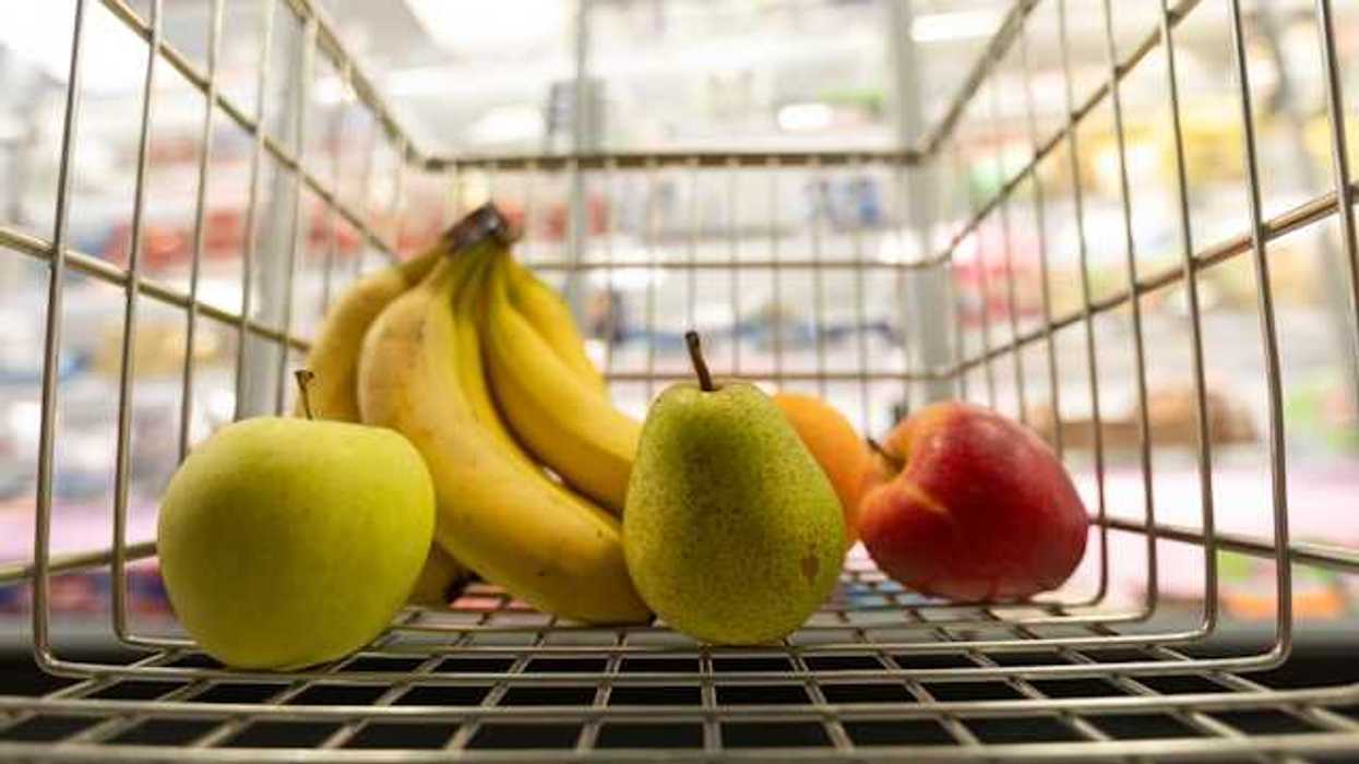 A grocery store cart filled with fruit