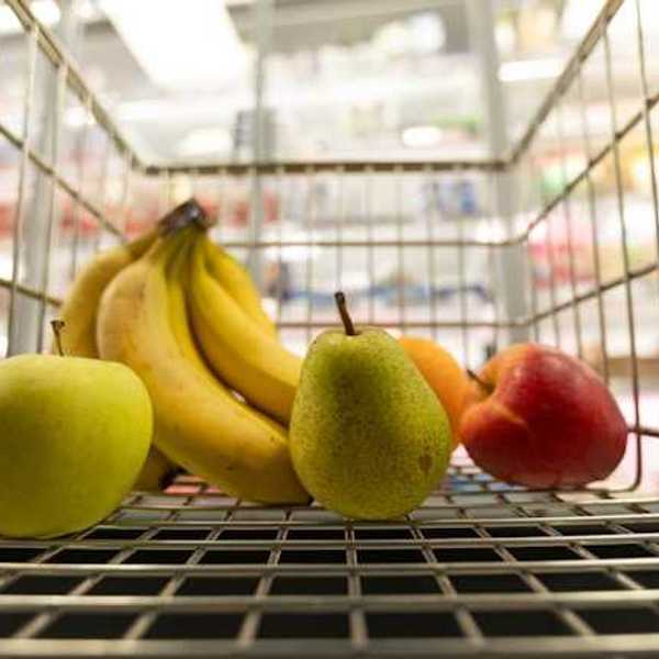 A grocery store cart filled with fruit