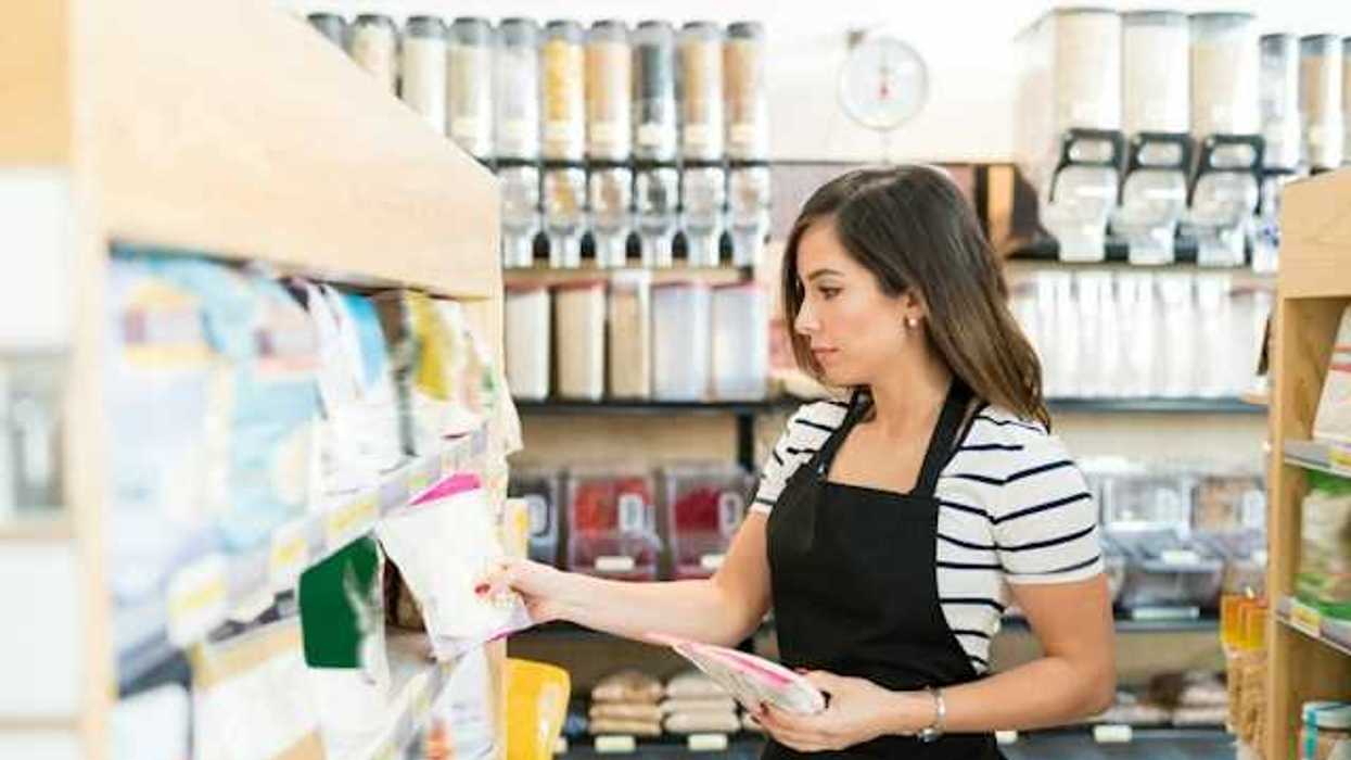 A grocery store worker placing items on a shelf