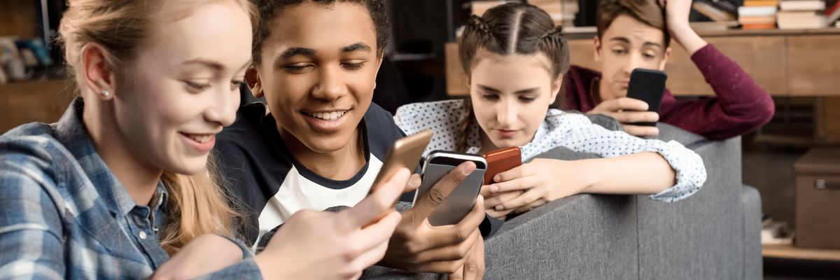 A group of adolescents look at their phones