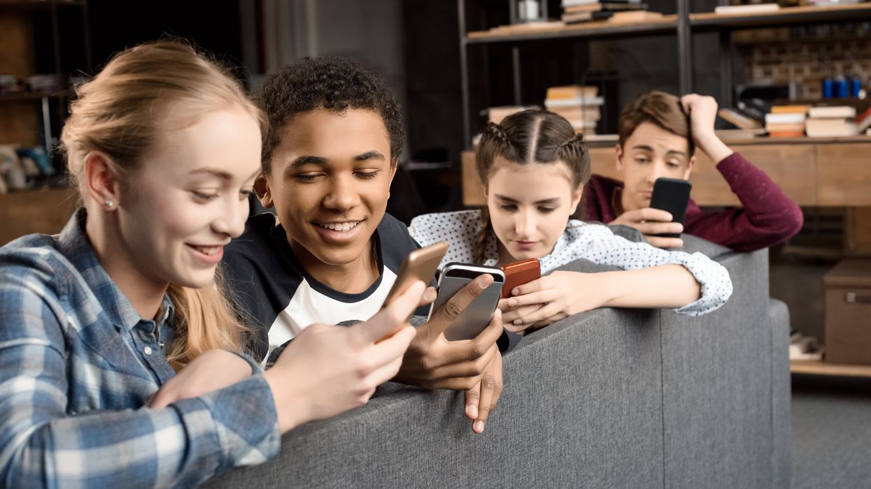 A group of adolescents look at their phones