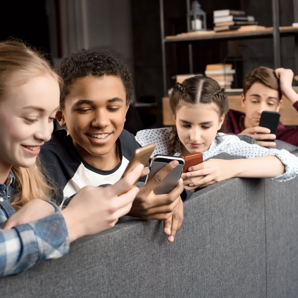 A group of adolescents look at their phones