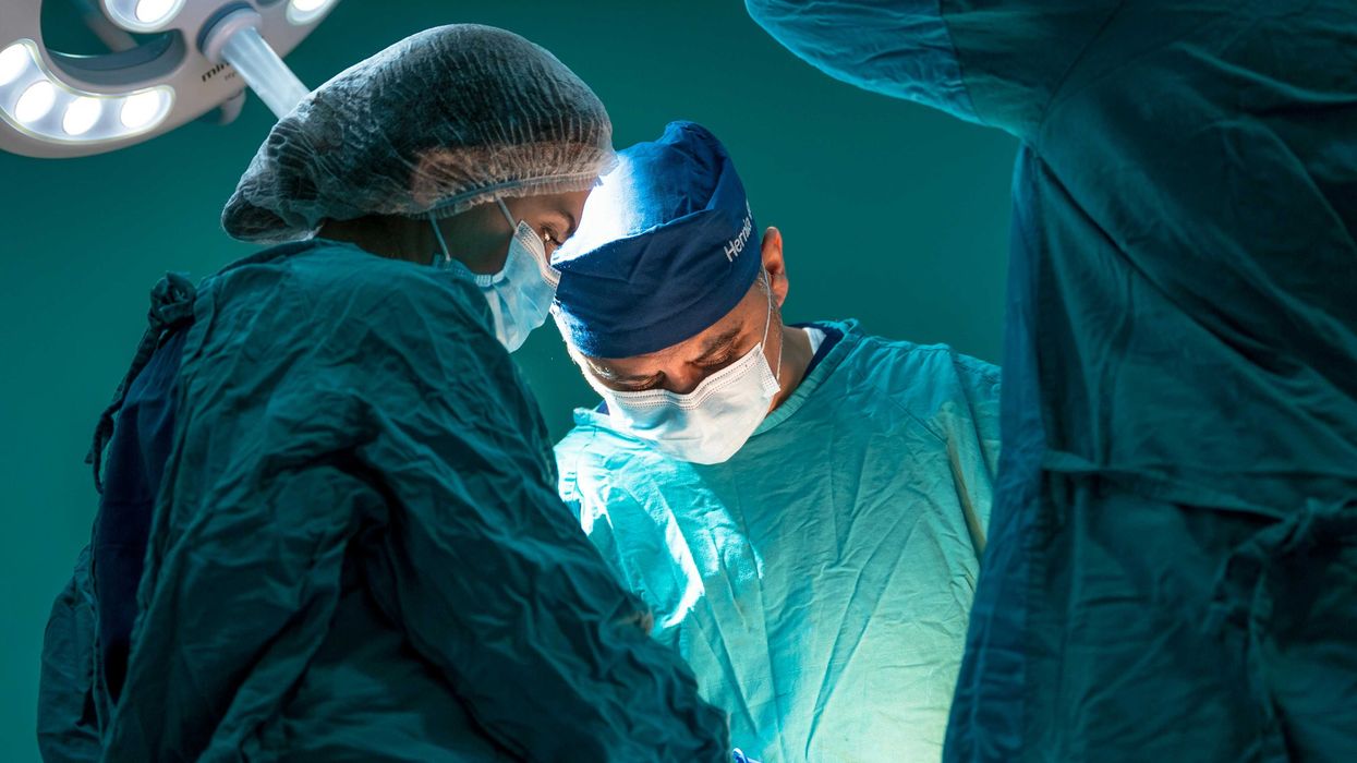 a group of doctors performing surgery on a patient.
