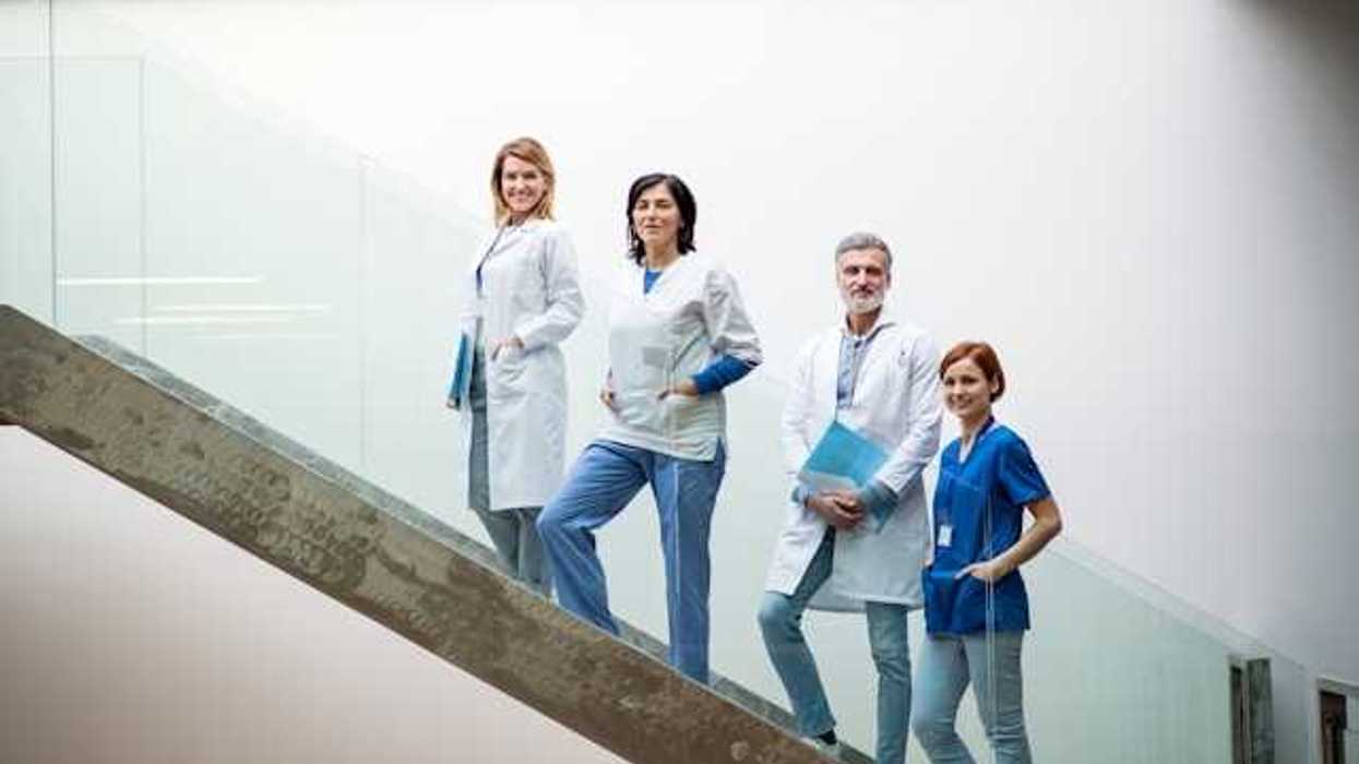 A group of health professionals standing on a concrete staircase