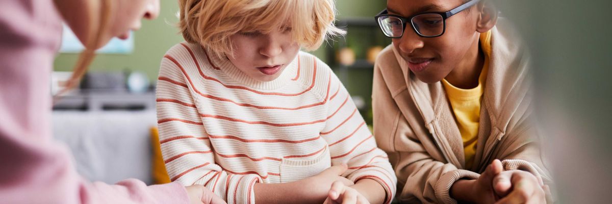 A group of kids play with a tablet