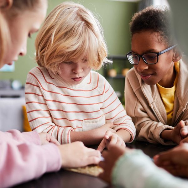 A group of kids play with a tablet