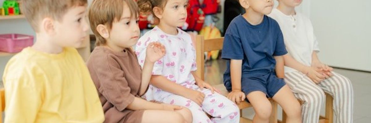 A group of kindergartners sitting in chairs.