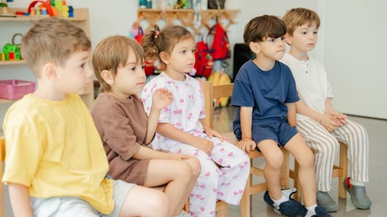 A group of kindergartners sitting in chairs.