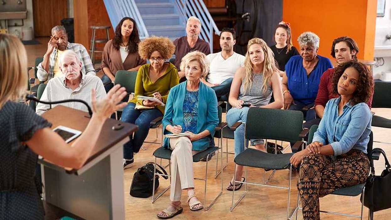 A group of people listening to a speaker at a community neeting