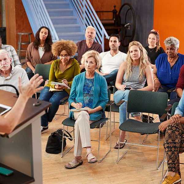 A group of people listening to a speaker at a community neeting