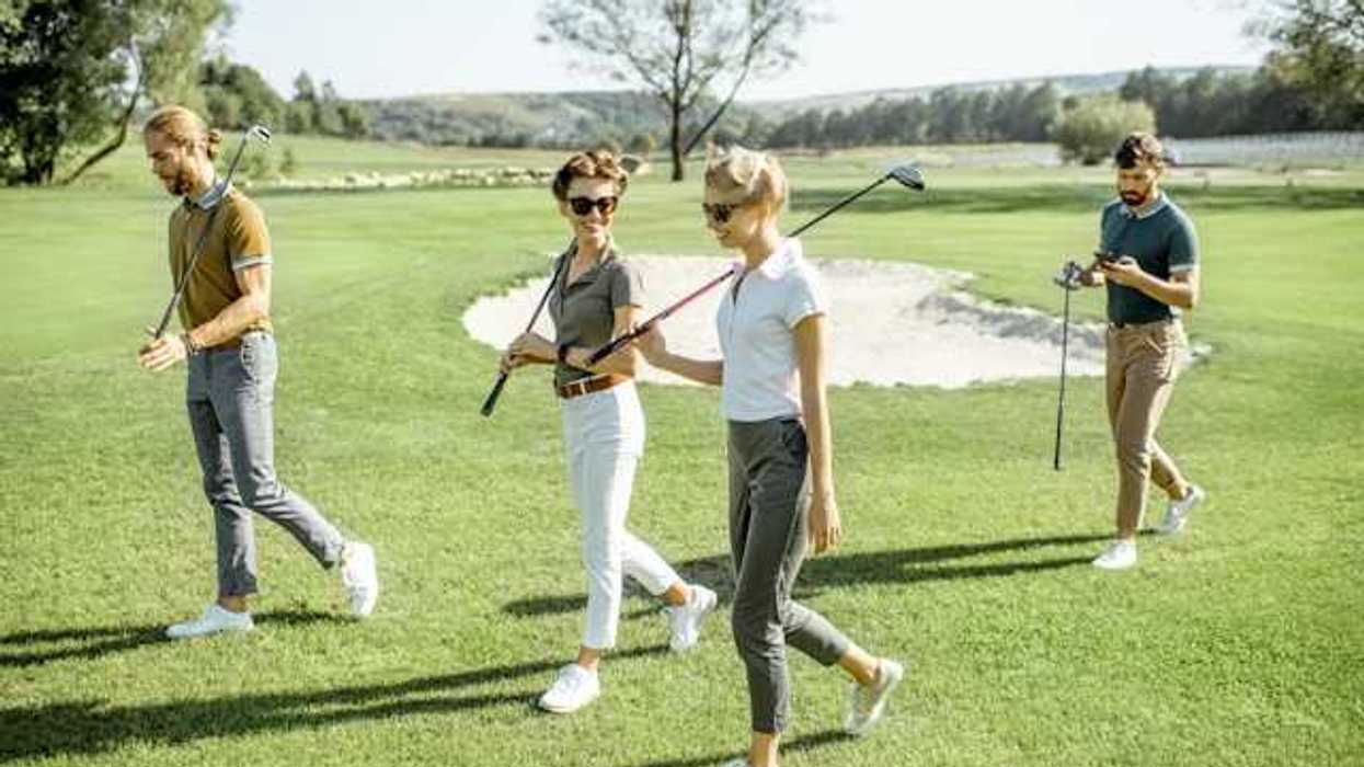 A group of people walking on a golf course