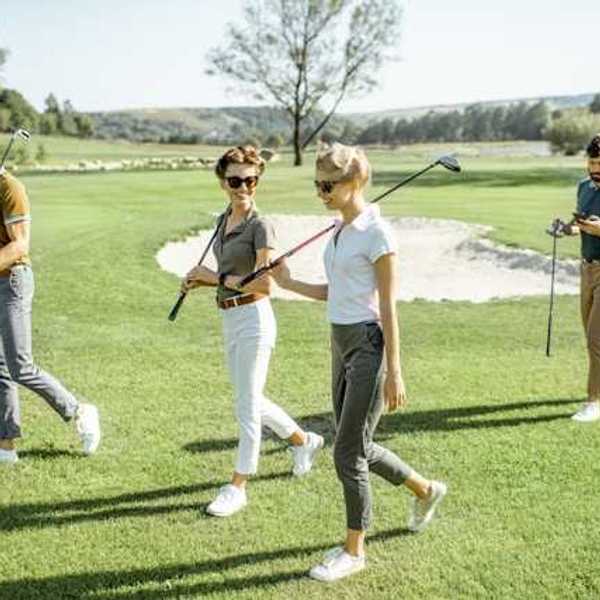 A group of people walking on a golf course