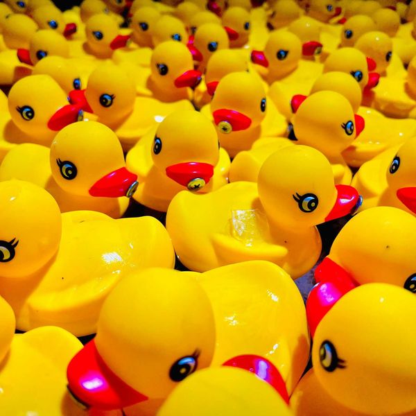a group of small rubber ducks that are yellow and red