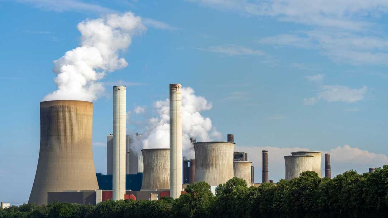 a group of smokestacks billowing pollution.