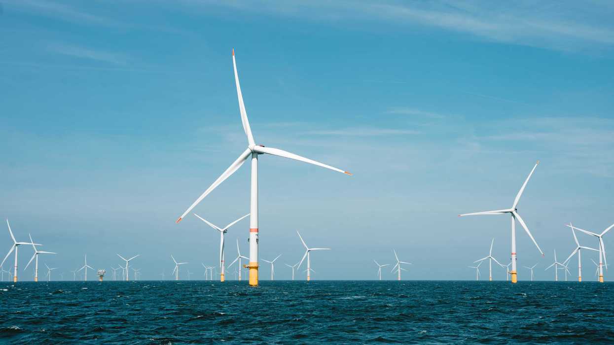 a group of wind turbines in the ocean.