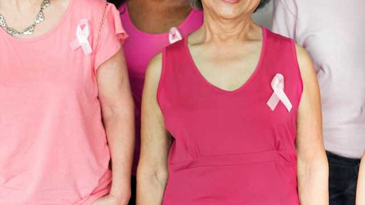A group of women with pink shirts and breast cancer awareness pins on