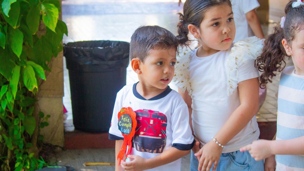 a group of young children standing next to each other.