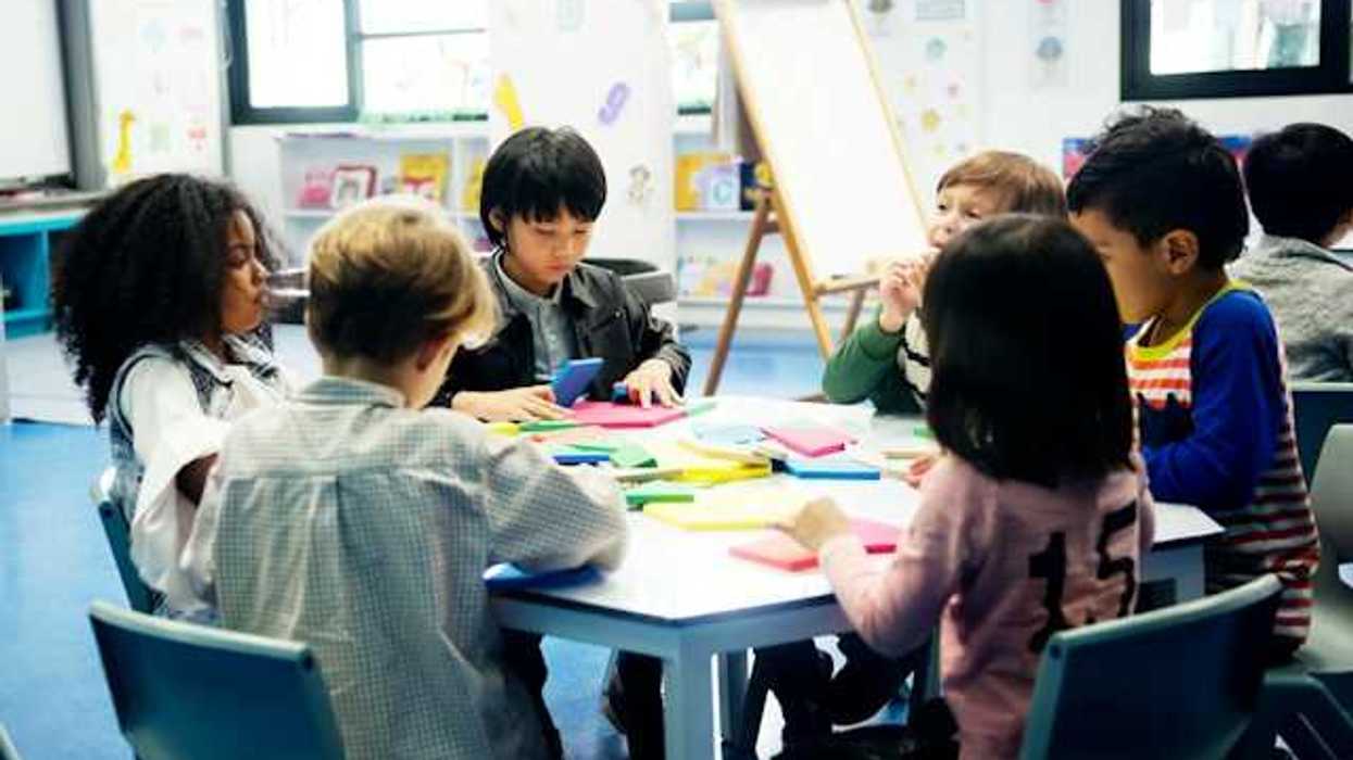 A group of young schoolchildren sitting around a table