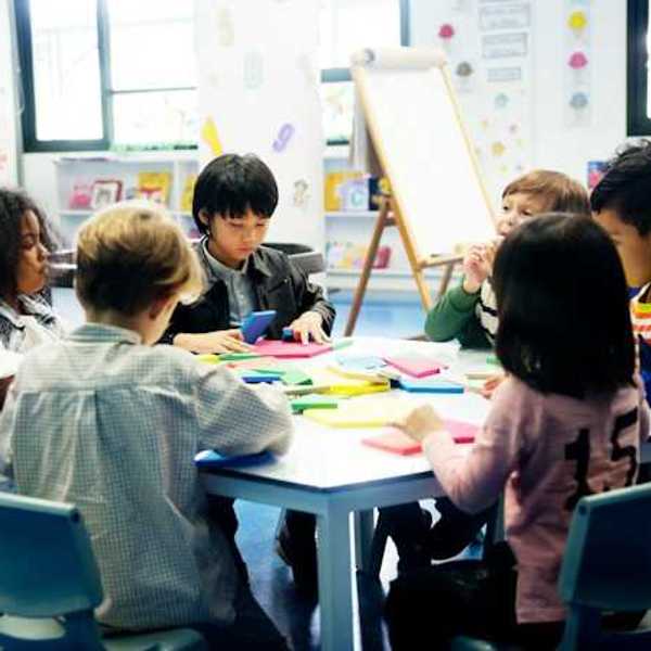 A group of young schoolchildren sitting around a table