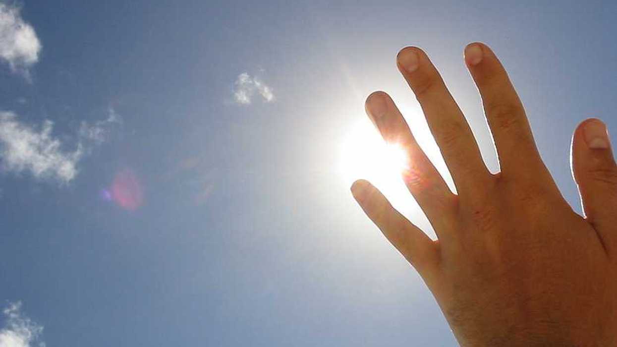 A hand blocking the sun's rays