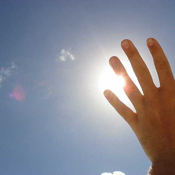A hand blocking the sun's rays