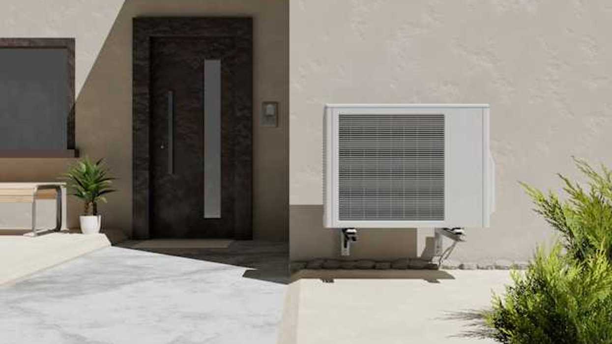 A heat pump attached to a wall outside a home