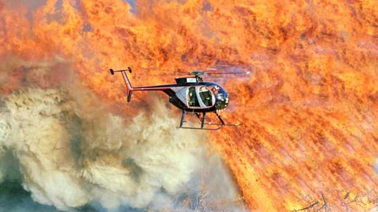 A helicopter flying over a large fire