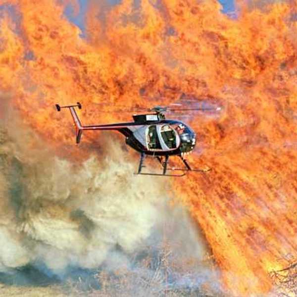 A helicopter flying over a large fire