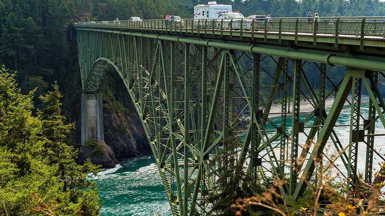 A high bridge carrying cars over an ocean inlet