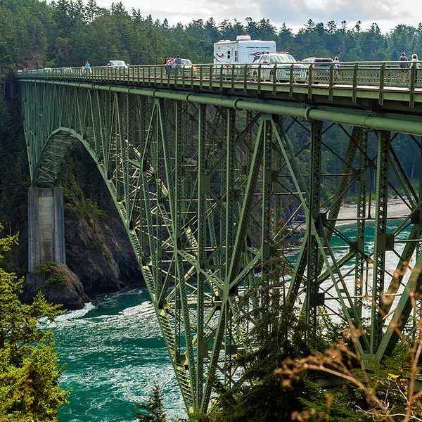 A high bridge carrying cars over an ocean inlet