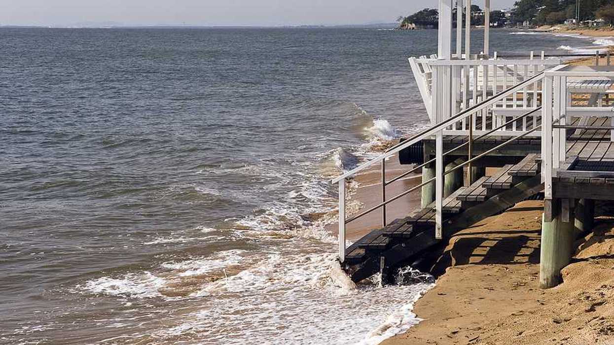 A home on a beach that is being inundated by sea water