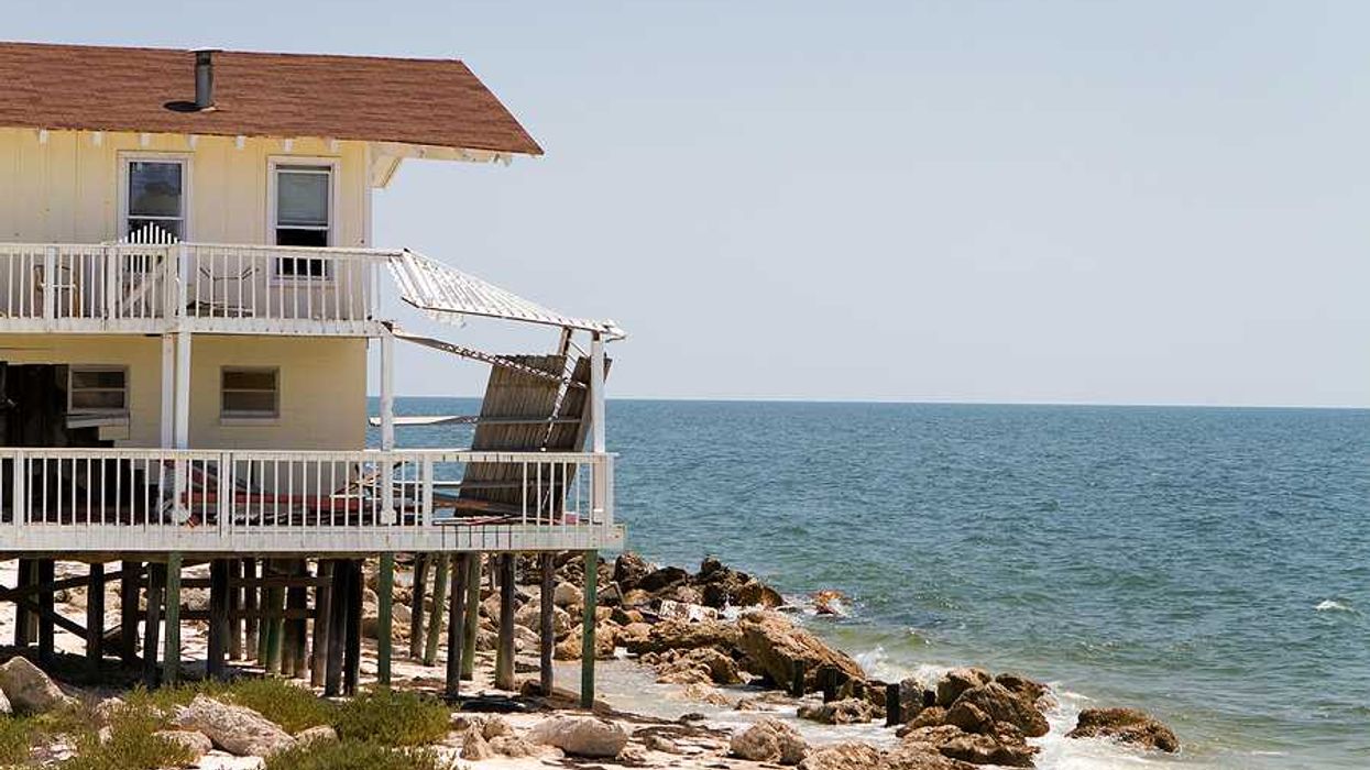 A home on stilts on the edge of an encroaching ocean