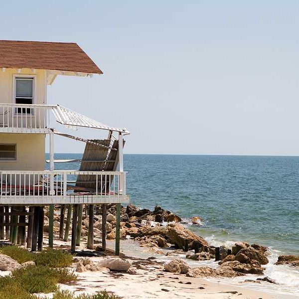 A home on stilts on the edge of an encroaching ocean