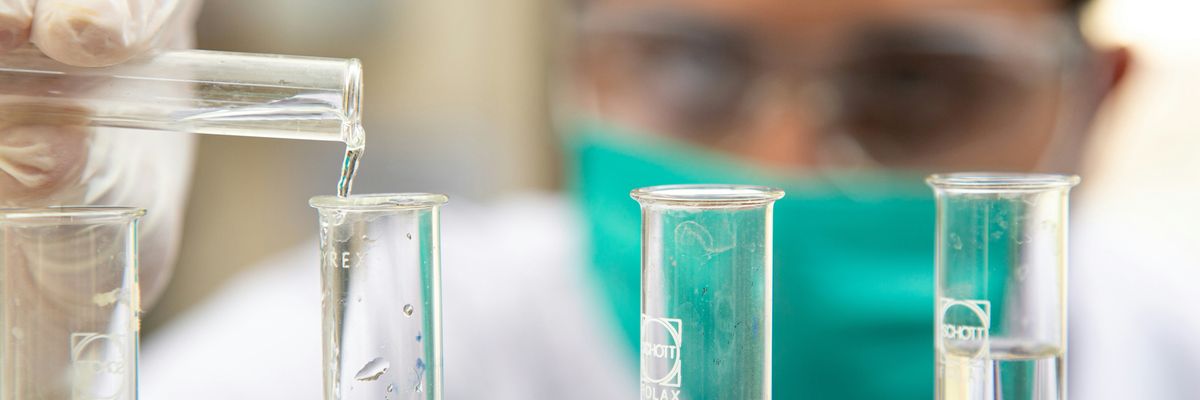 A lab tech works with testubes