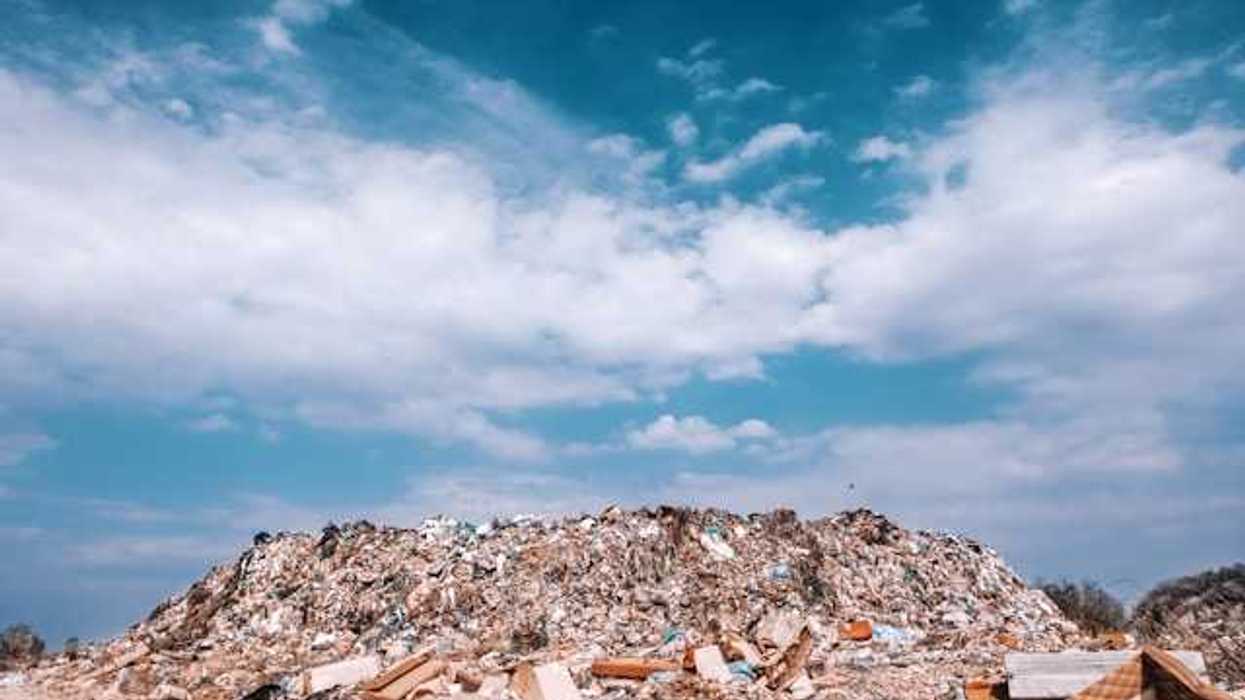 A landfill with the blue sky and clouds in the background