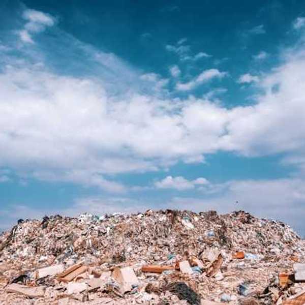 A landfill with the blue sky and clouds in the background