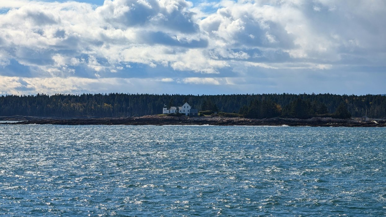 A large body of water with a lighthouse in the distance.