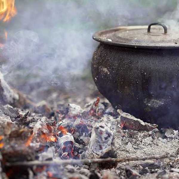 A large cast iron pot on an open fire