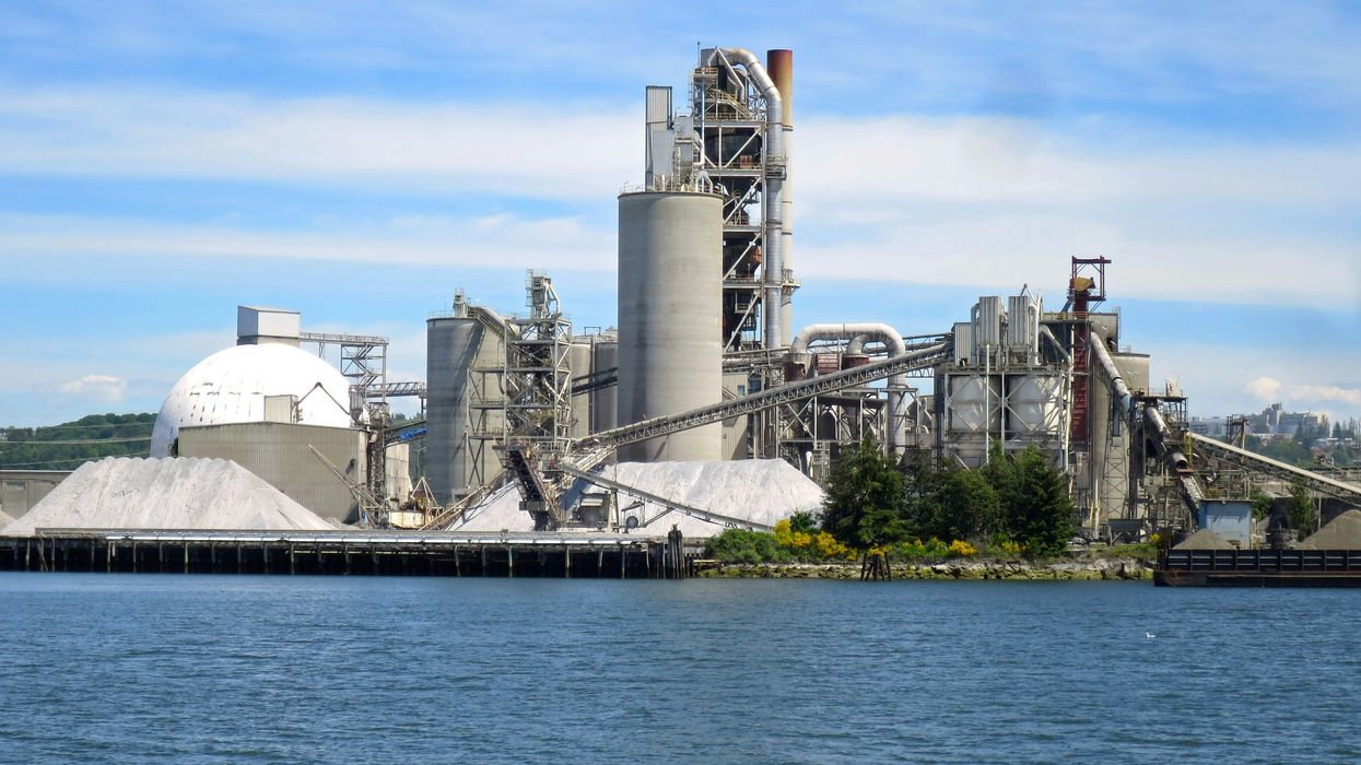 a large factory building next to a body of water.