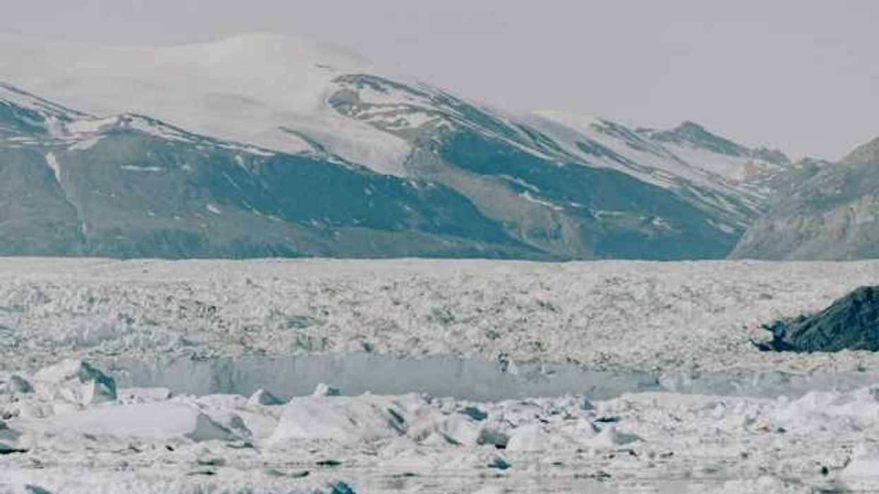 A large glacier with mountains in the background