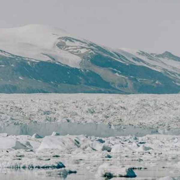A large glacier with mountains in the background