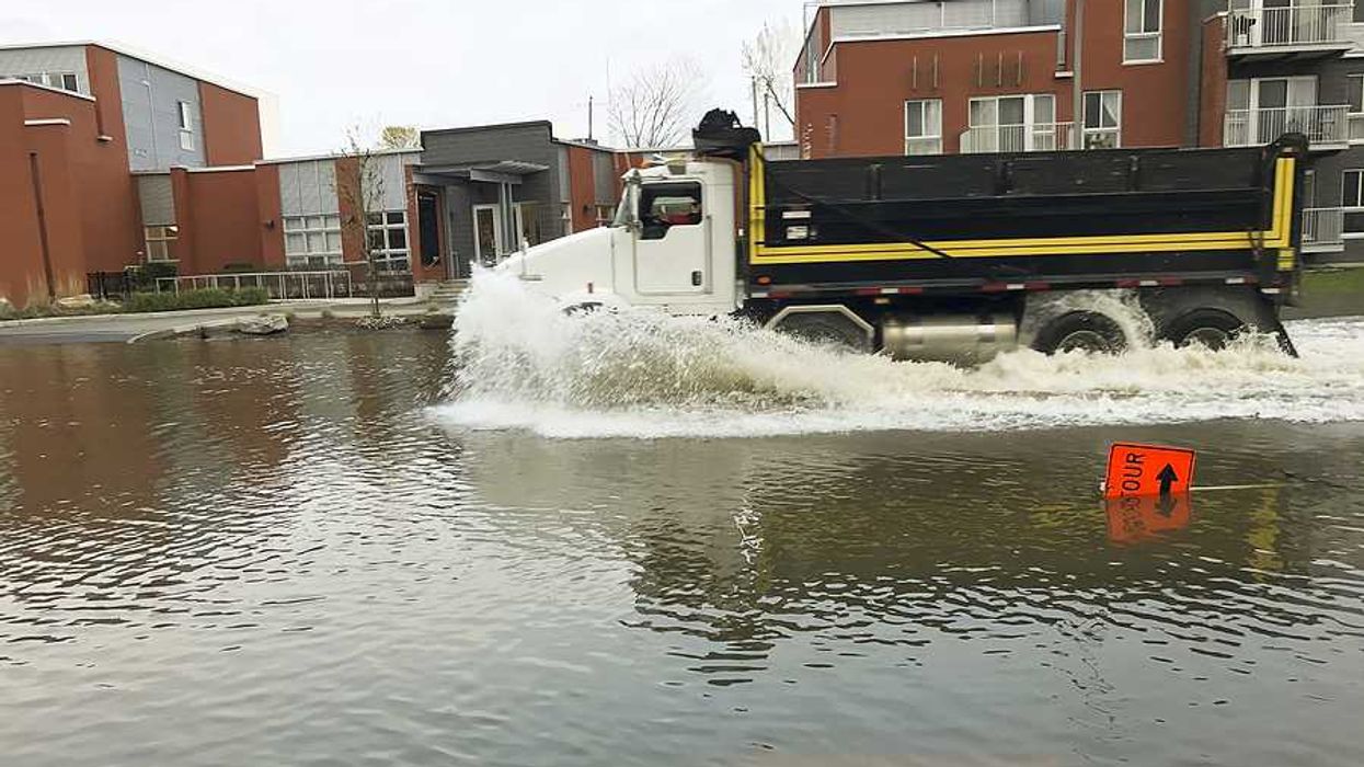 A large truck driving through a flooded street