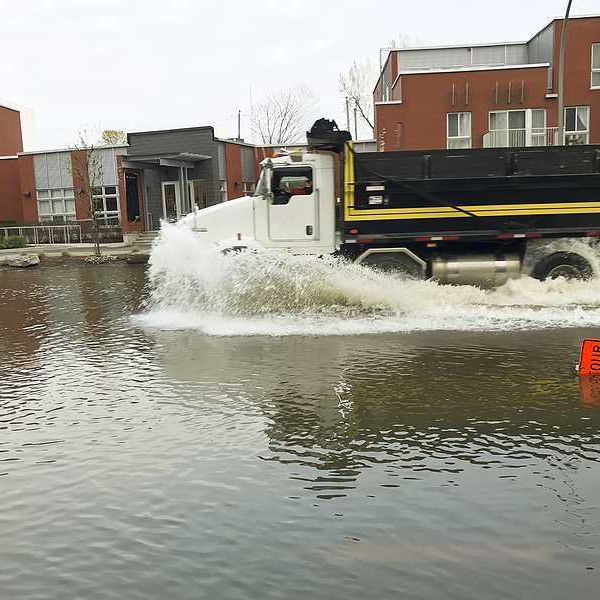 A large truck driving through a flooded street