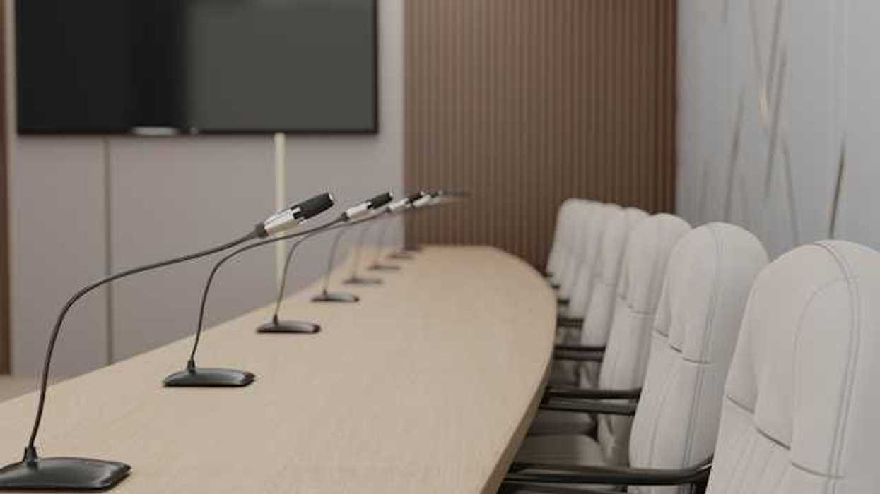 A long table with microphones at each seat