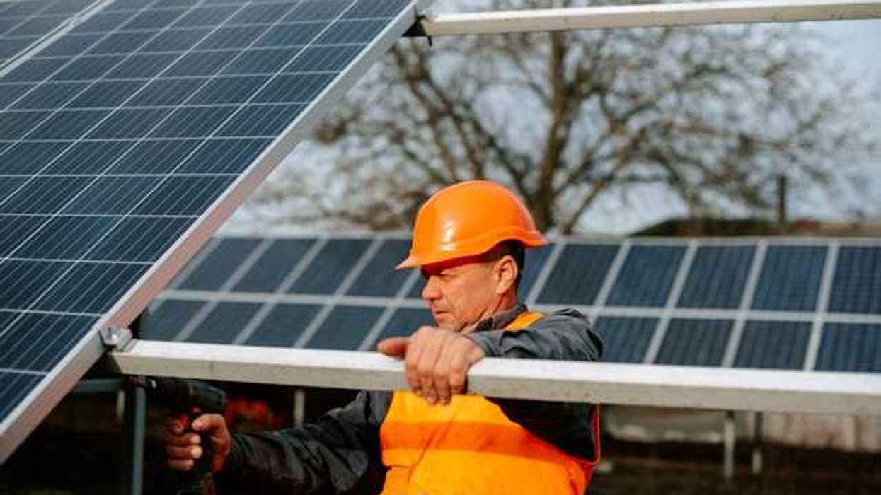 A maintenance worker installing solar panels