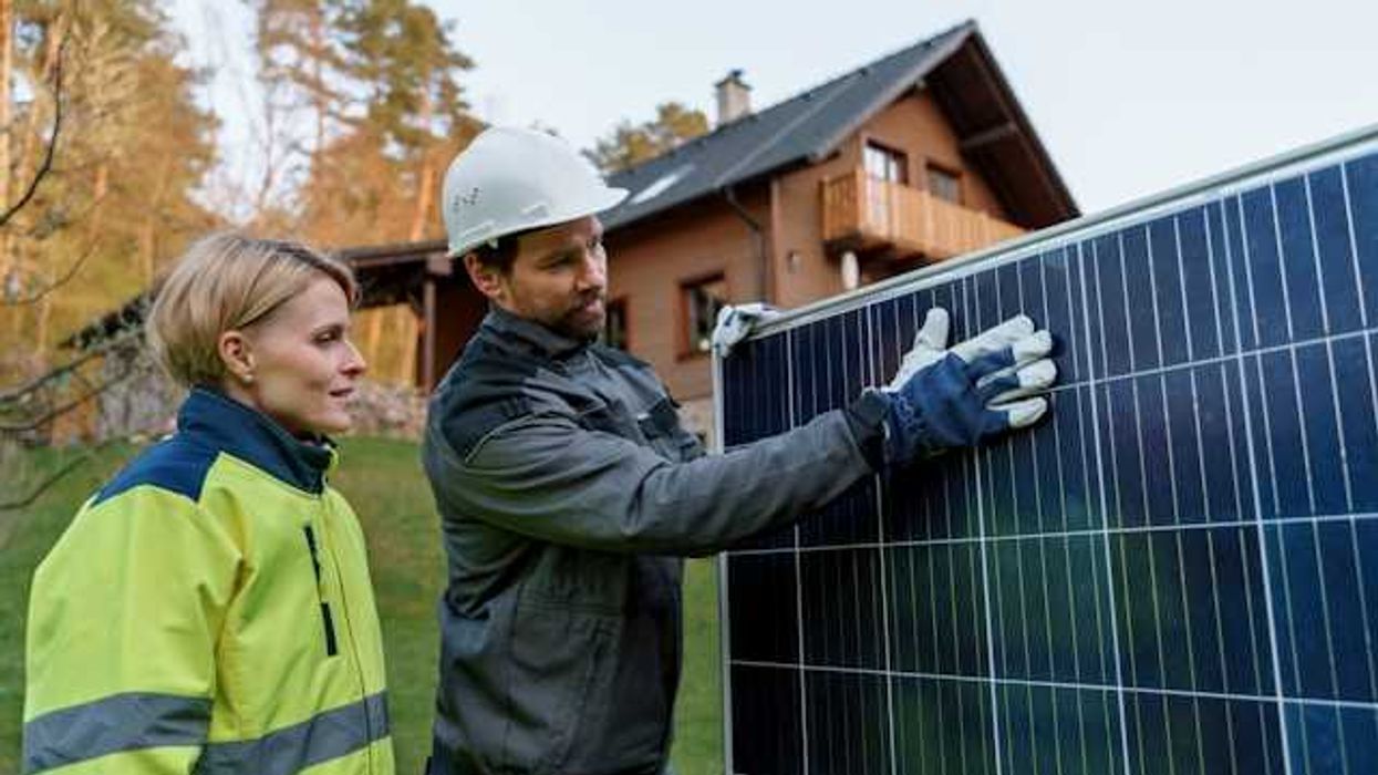A man and woman inspecting a solar panel
