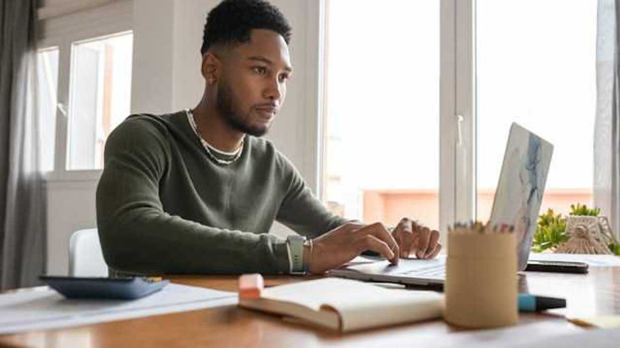 A man at a table working on a computer